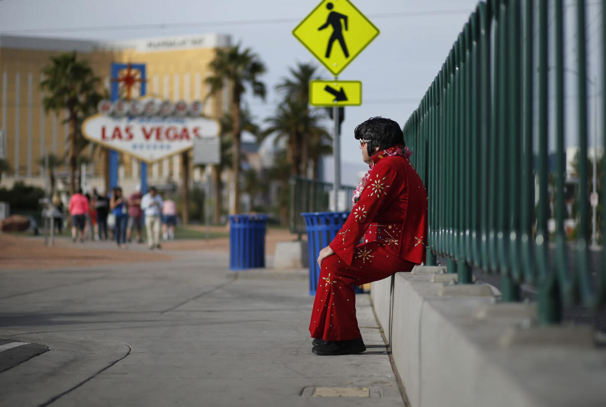 Ted Payne rests March 3 as he works for tips dressed as Elvis at the &quot;Welcome to Las Vegas&quot; sign in Las Vegas. For decades, Las Vegas has loved Elvis Presley. But the King&#039;s presence in modern day Sin City has lately been diminishing.