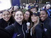 Washington players huddle together for a selfie during a sendoff rally for the Washington women&#039;s basketball team. The Huskies play Syracuse in a national semifinal on Sunday. Prairie graduate Heather Corral is seen in the center, wearing glasses.