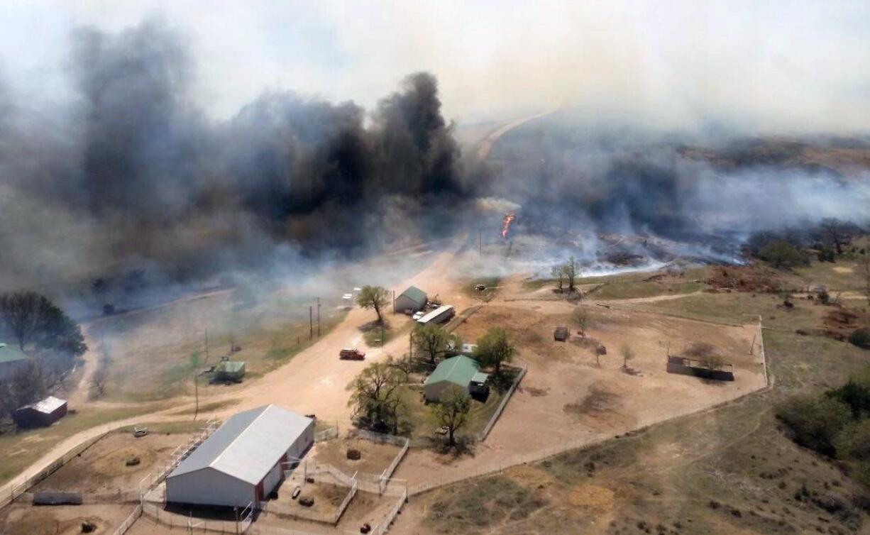 The Anderson Creek fire on Wednesday approaches a home and other structures in Woods County, Okla. Hundreds of firefighters were battling a wildfire that spread from Oklahoma to Kansas and has burned an estimated 620 square miles.