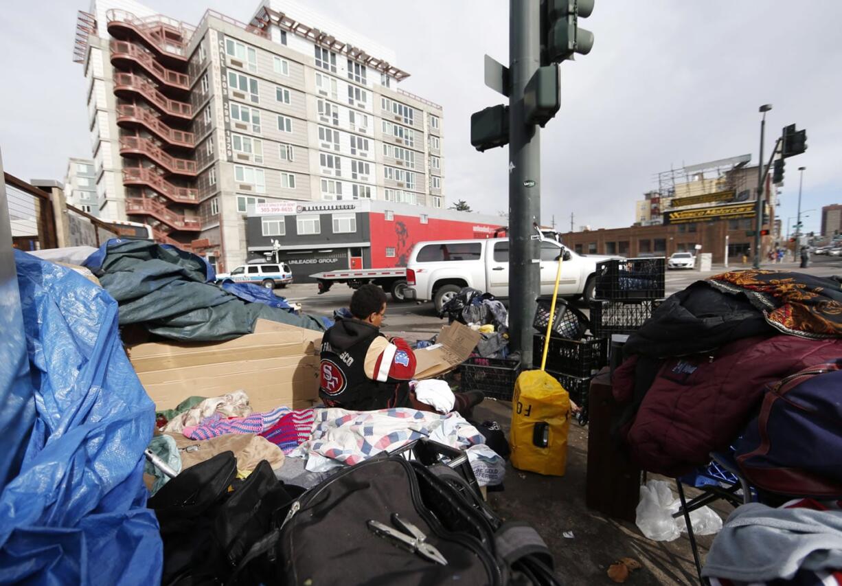 An unidentified woman packs up her belongings in a makeshift homeless camp across from the Denver Rescue Mission on Monday, March 7, 2016, in downtown Denver. City officials evicted people Tuesday, March 8, from the homeless camps that have popped up around homeless shelters and in public places around the Mile-High City.