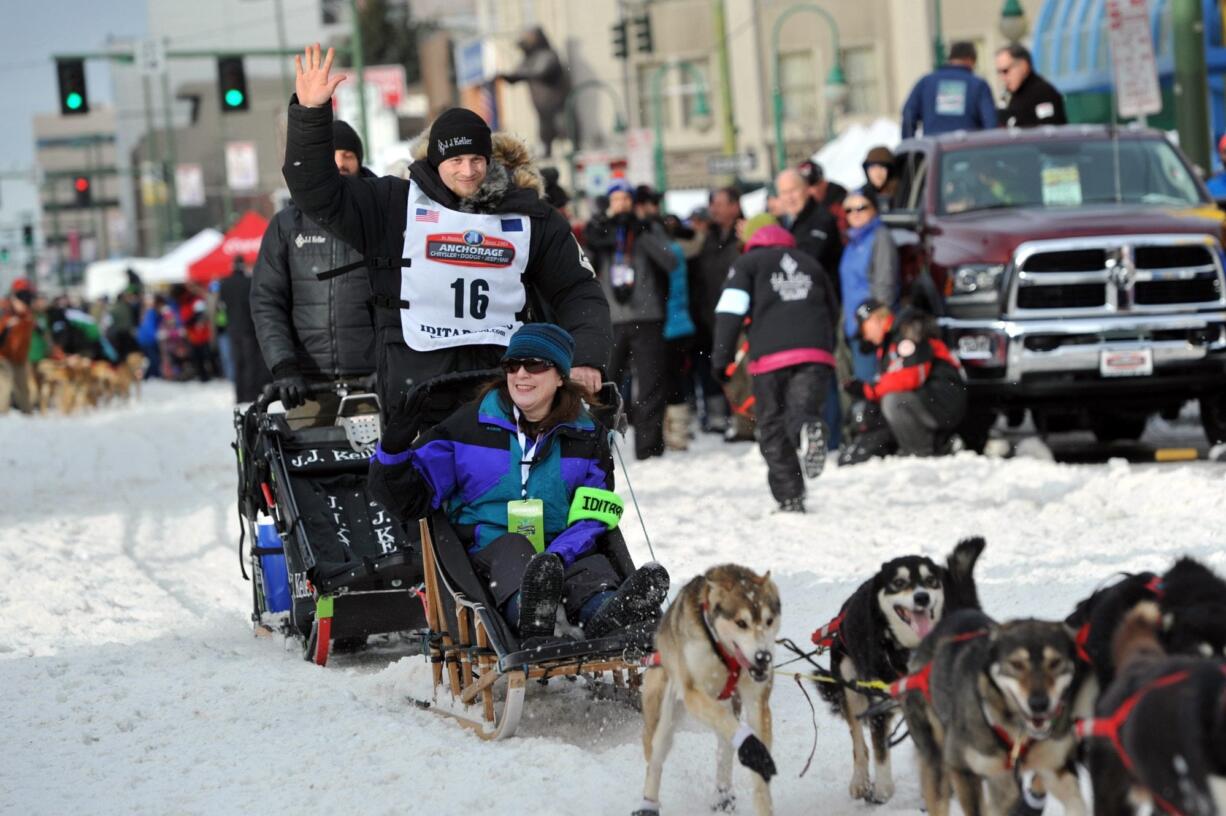 Defending Iditarod Trail Sled Dog Race champion Dallas Seavey (16) waves to the crowd as she begins the ceremonial start of the 1,000-mile race in Anchorage, Alaska, on March 5.