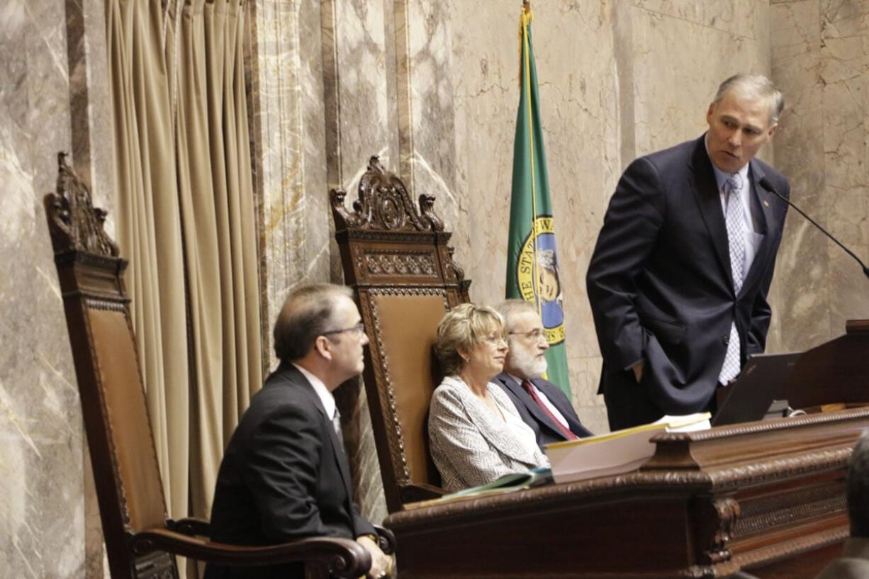 Gov. Jay Inslee, right, thanks Lt. Gov. Brad Owen, left, for his service Tuesday after Owen announced to the Senate that he was retiring at the end of his term.