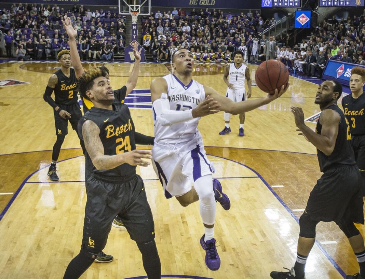 Washington&#039;s Andrew Andrews, center, jumps over Long Beach State&#039;s Travis Hammonds in the lane during the first round of a National Invitational Tournament NCAA college basketball game on Tuesday, March 15, 2016 at Alaska Airlines Arena in Seattle. (Dean Rutz/The Seattle Times via AP) OUTS: SEATTLE OUT, USA TODAY OUT, MAGAZINES OUT, ONLINE OUT, TELEVISION OUT, SALES OUT.