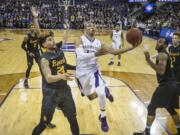 Washington&#039;s Andrew Andrews, center, jumps over Long Beach State&#039;s Travis Hammonds in the lane during the first round of a National Invitational Tournament NCAA college basketball game on Tuesday, March 15, 2016 at Alaska Airlines Arena in Seattle. (Dean Rutz/The Seattle Times via AP) OUTS: SEATTLE OUT, USA TODAY OUT, MAGAZINES OUT, ONLINE OUT, TELEVISION OUT, SALES OUT.