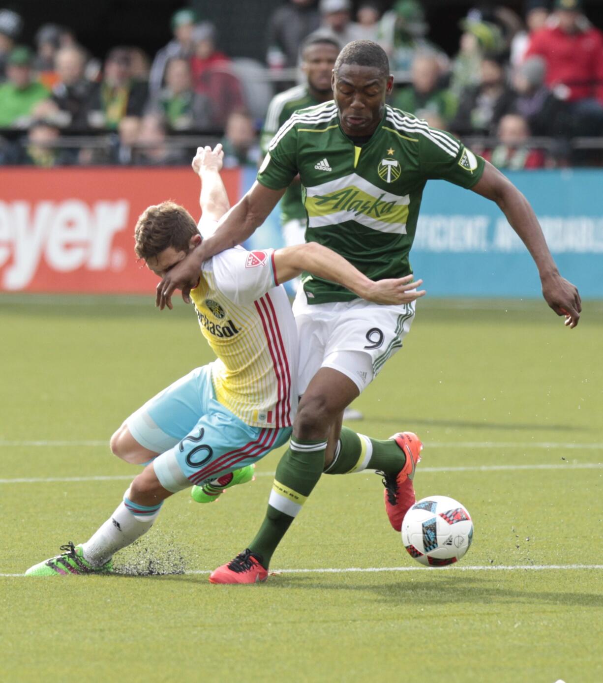 Portland Timbers forward Fanendo Adi (9) and Columbus Crew midfielder Will Trapp (20) battle for the ball during the first half of an MLS soccer match in Portland, Ore., Sunday, March 6, 2016.