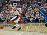 Portland Trail Blazers guard Gerald Henderson, left, dribbles past Orlando Magic forward Devyn Marble, right, during the second half of an NBA basketball game in Portland, Ore., Saturday, March 12, 2016.