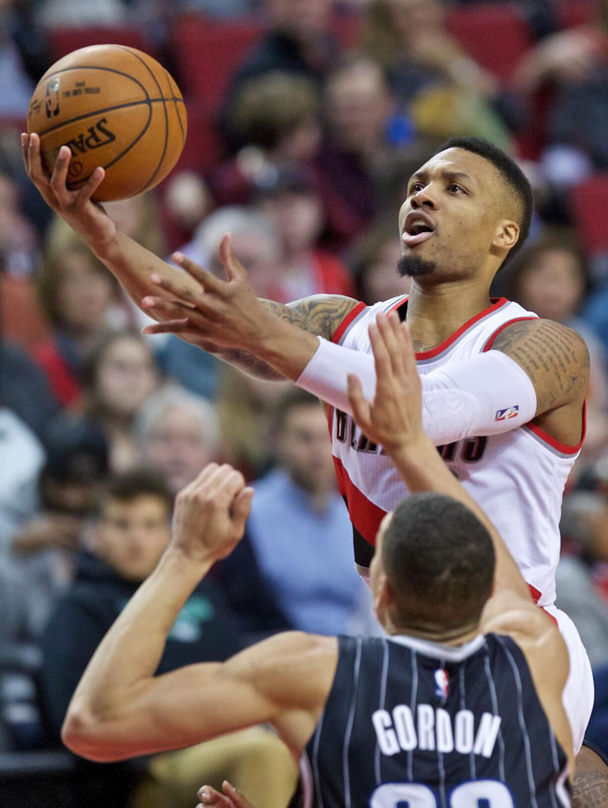 Portland Trail Blazers guard Damian Lillard, right, shoots over Orlando Magic forward Aaron Gordon during the second half of an NBA basketball game in Portland, Ore., Saturday, March 12, 2016.