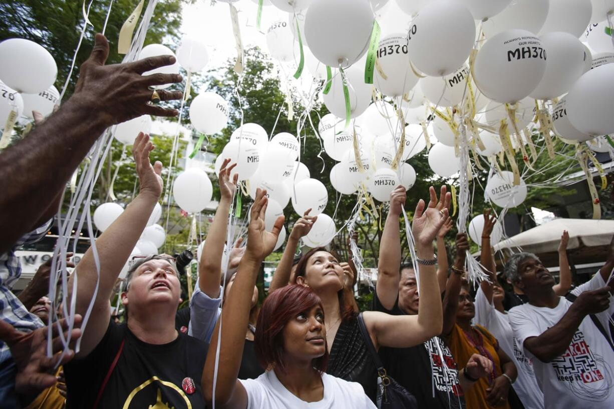 Jacquita Gomes, 54, Grace Subathirai Nathan, 28, and Melanie Antonio, from left, and other relatives of passengers and crew of Flight 370 release balloons with the names of those who were on board.