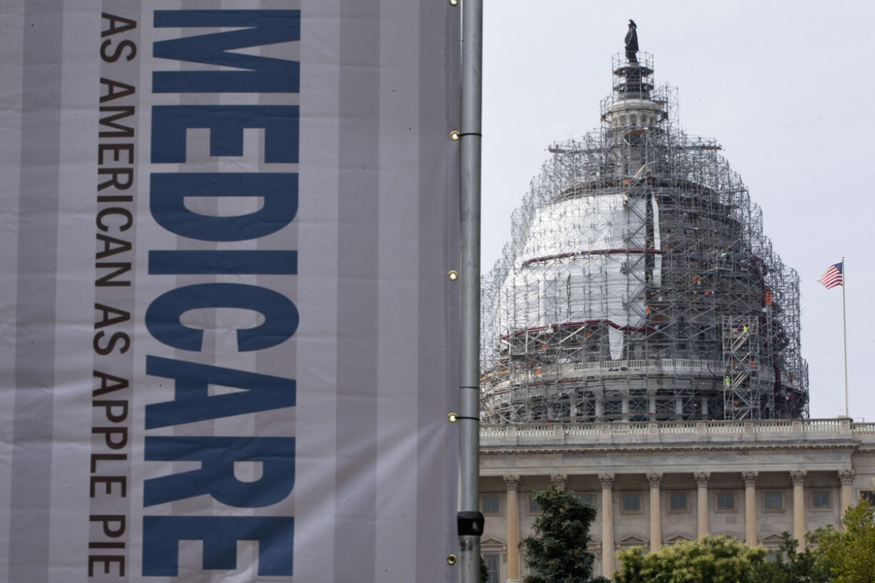 FILE - In this July 30, 2015 file photo, a sign supporting Medicare is seen on Capitol Hill in Washington as registered nurses and other community leaders celebrate the 50th anniversary of Medicare and Medicaid. Medicare. From Akron to Tampa Bay, from New York City to San Francisco, Medicare on Friday, April 1, 2016, launches an ambitious experiment changing how it pays for hip and knee replacements to raise quality and lower costs.