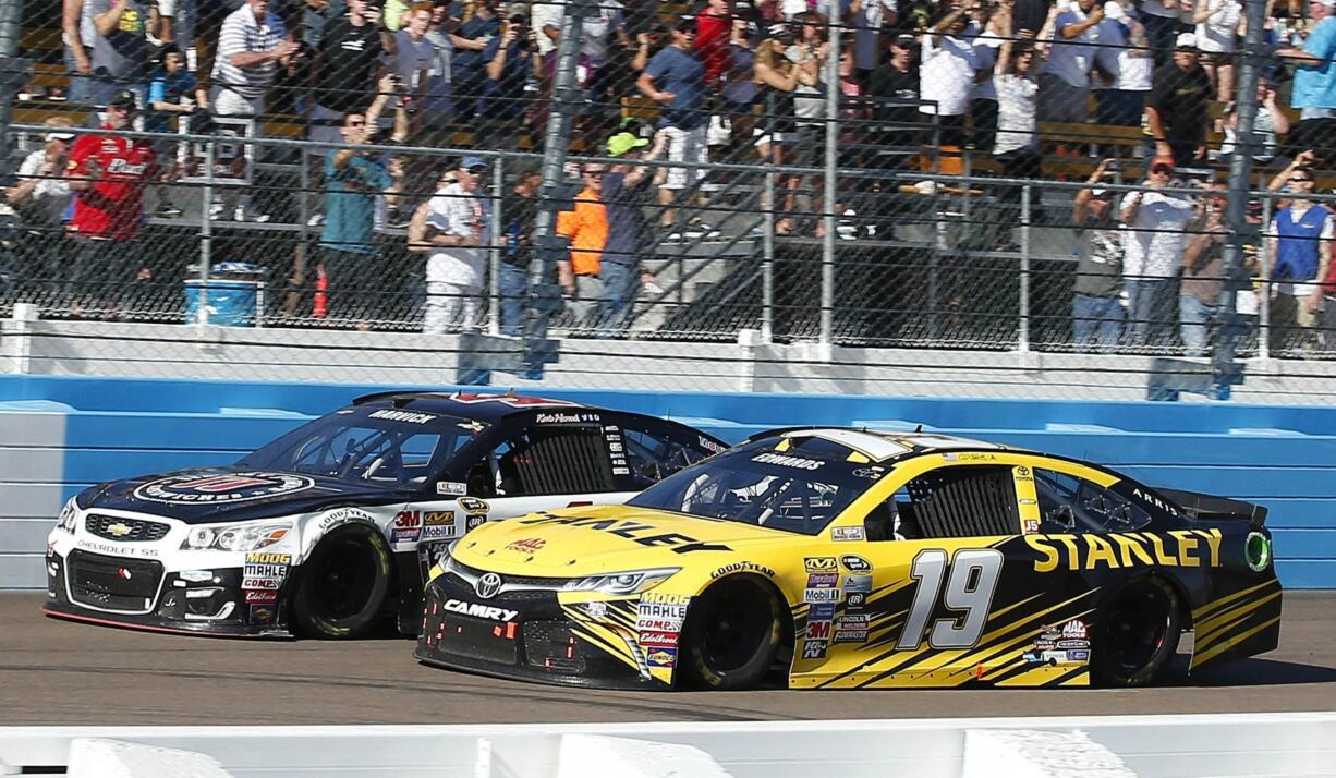 Carl Edwards, right, collides with Kevin Harvick, left, at the finish line during a NASCAR Sprint Cup Series auto race at Phoenix International Raceway Sunday, March 13, 2016, in Avondale, Ariz. Harvick narrowly defeated Edwards at the finish. (AP Photo/Ross D.