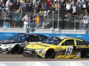 Carl Edwards, right, collides with Kevin Harvick, left, at the finish line during a NASCAR Sprint Cup Series auto race at Phoenix International Raceway Sunday, March 13, 2016, in Avondale, Ariz. Harvick narrowly defeated Edwards at the finish. (AP Photo/Ross D.