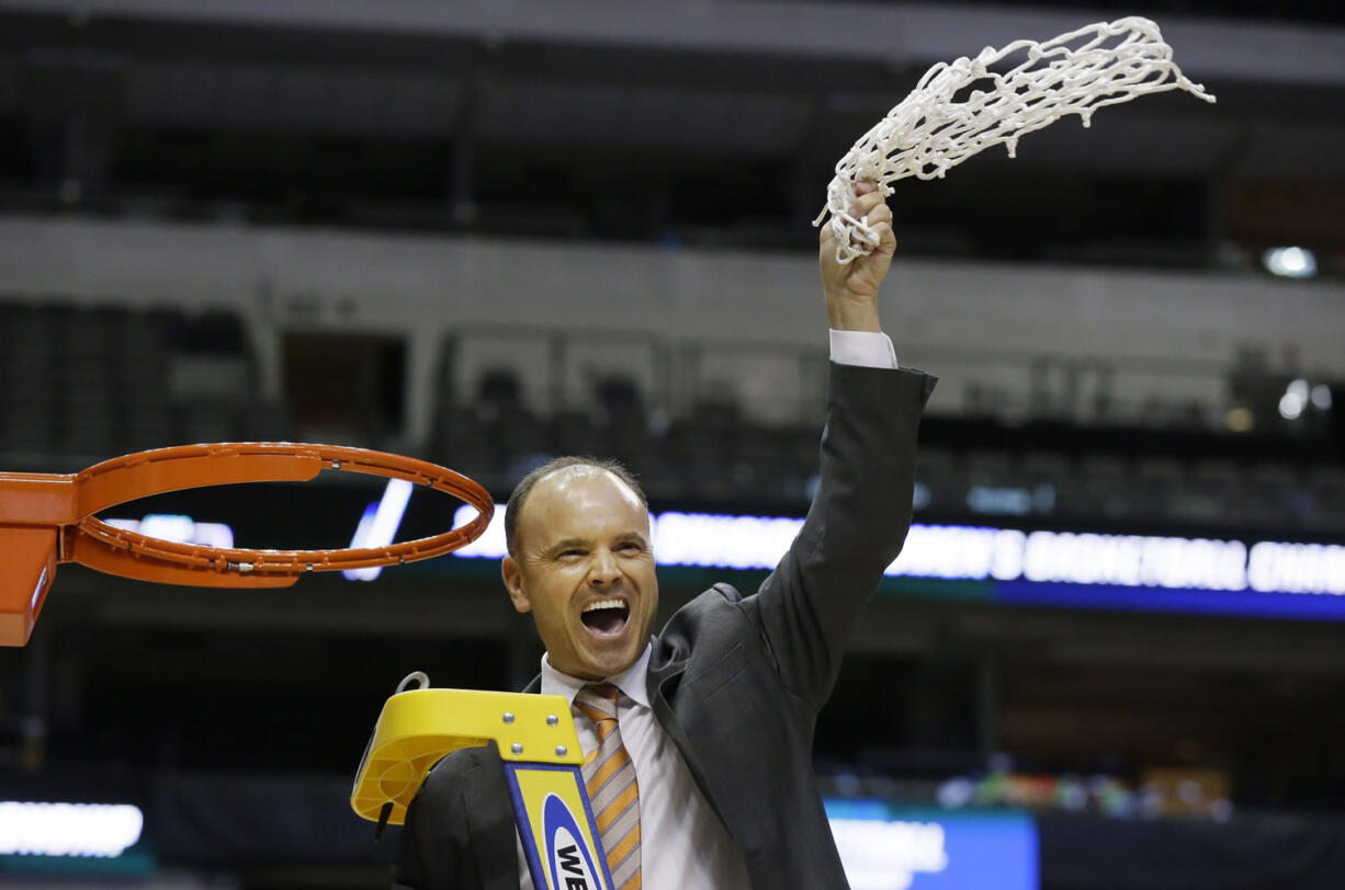 Oregon State coach Scott Rueck waves the net after cutting it off the rim after winning the regional title.