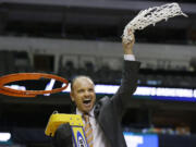 Oregon State coach Scott Rueck waves the net after cutting it off the rim after winning the regional title.