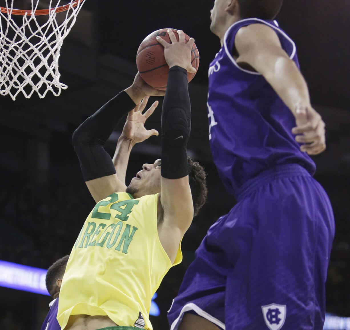 Oregon forward Dillon Brooks (24) shoots against of Holy Cross forward Eric Green, right, and forward Malachi Alexander (21) during the first half of a first-round men's college basketball game in the NCAA Tournament in Spokane, Wash., Friday, March 18, 2016.