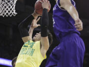 Oregon forward Dillon Brooks (24) shoots against of Holy Cross forward Eric Green, right, and forward Malachi Alexander (21) during the first half of a first-round men's college basketball game in the NCAA Tournament in Spokane, Wash., Friday, March 18, 2016.