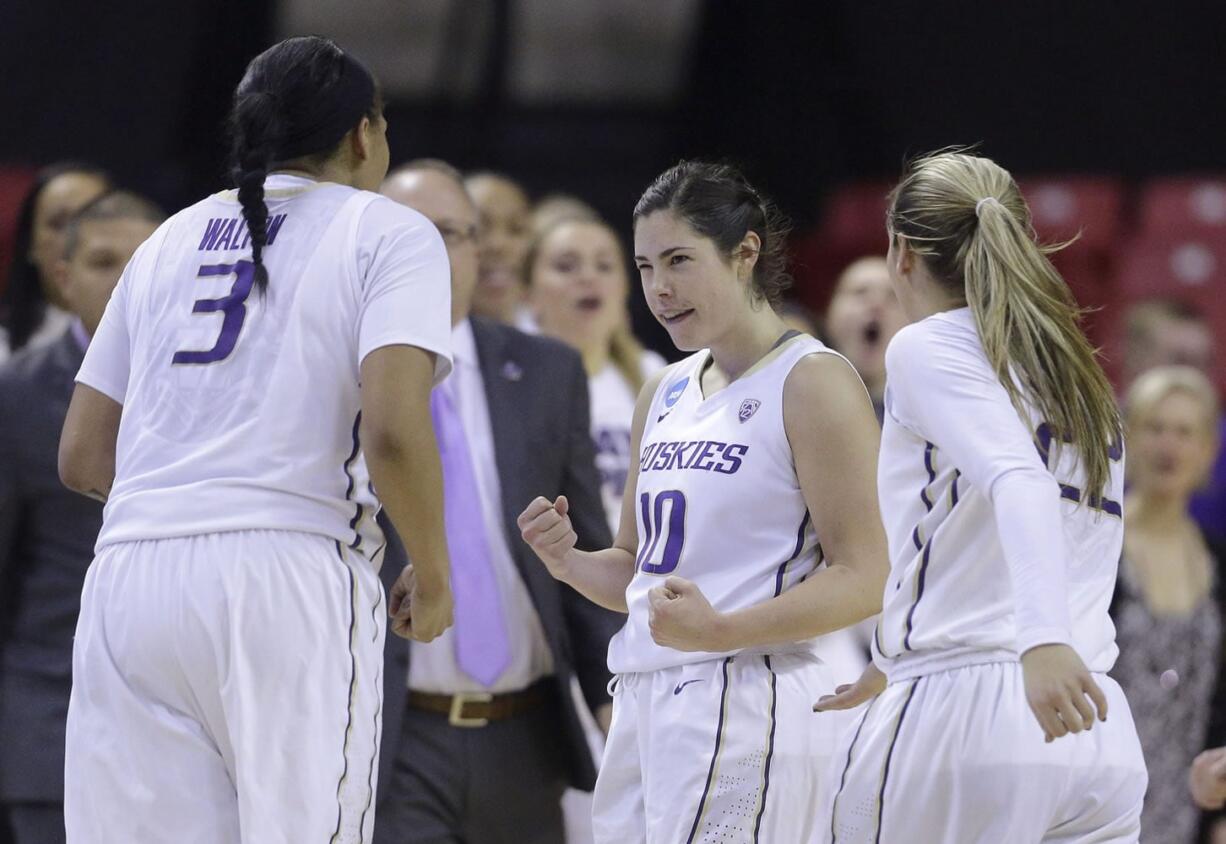 Washington guard Kelsey Plum, center, celebrates with teammates Talia Walton, left, and Alexus Atchley durng the Huskies&#039; win over Penn in the NCAA Tournament.