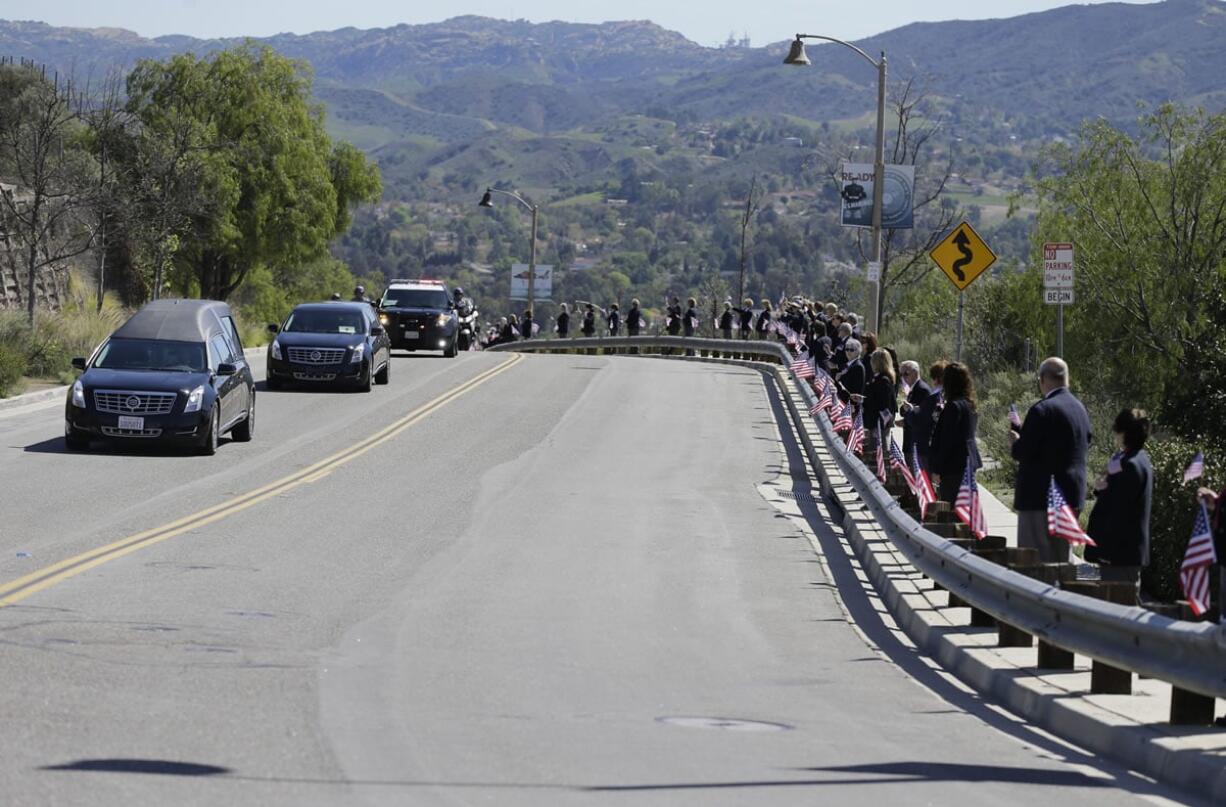 Library volunteers line the road as the hearse carrying the body of Nancy Reagan arrives at the Ronald Reagan Presidential Library on Wednesday in Simi Valley, Calif. (jae c.