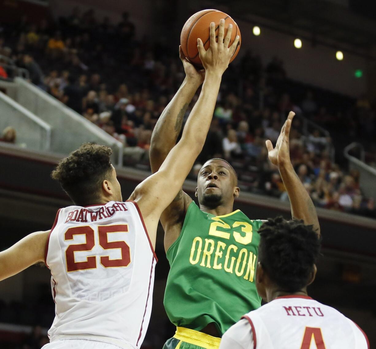 Southern California's Bennie Boatwright, left, blocks a shot attempt by Oregon's Elgin Cook, center, while Southern Cal's Chimezie Metu, right, looks on during the first half of an NCAA college basketball game, Saturday, March 5, 2016, in Los Angeles.