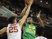 Southern California's Bennie Boatwright, left, blocks a shot attempt by Oregon's Elgin Cook, center, while Southern Cal's Chimezie Metu, right, looks on during the first half of an NCAA college basketball game, Saturday, March 5, 2016, in Los Angeles.