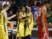 Oregon guard Tyler Dorsey, center left, embraces forward Dillon Brooks as they celebrate after Oregon defeated Utah in an NCAA college basketball game in the championship of the Pac-12 men's tournament Saturday, March 12, 2016, in Las Vegas. Oregon won 88-57.