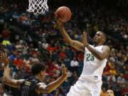 Oregon forward Elgin Cook shoots over Washington forward Marquese Chriss during the second half of an NCAA college basketball game in the quarterfinal round of the Pac-12 men's tournament Thursday, March 10, 2016, in Las Vegas. Oregon won 83-77.