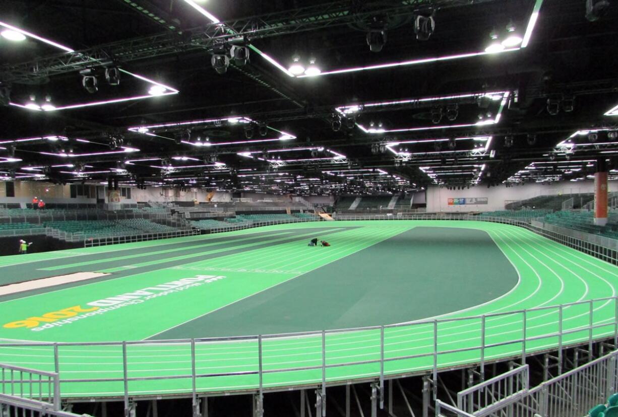 Workers put the finishing touches on the track at the Oregon Convention Center in Portland on Monday. The track will host the U.S. indoor track and field championships starting Friday and the IAAF World Indoor Championships the following week. (Anne M.