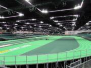 Workers put the finishing touches on the track at the Oregon Convention Center in Portland on Monday. The track will host the U.S. indoor track and field championships starting Friday and the IAAF World Indoor Championships the following week. (Anne M.