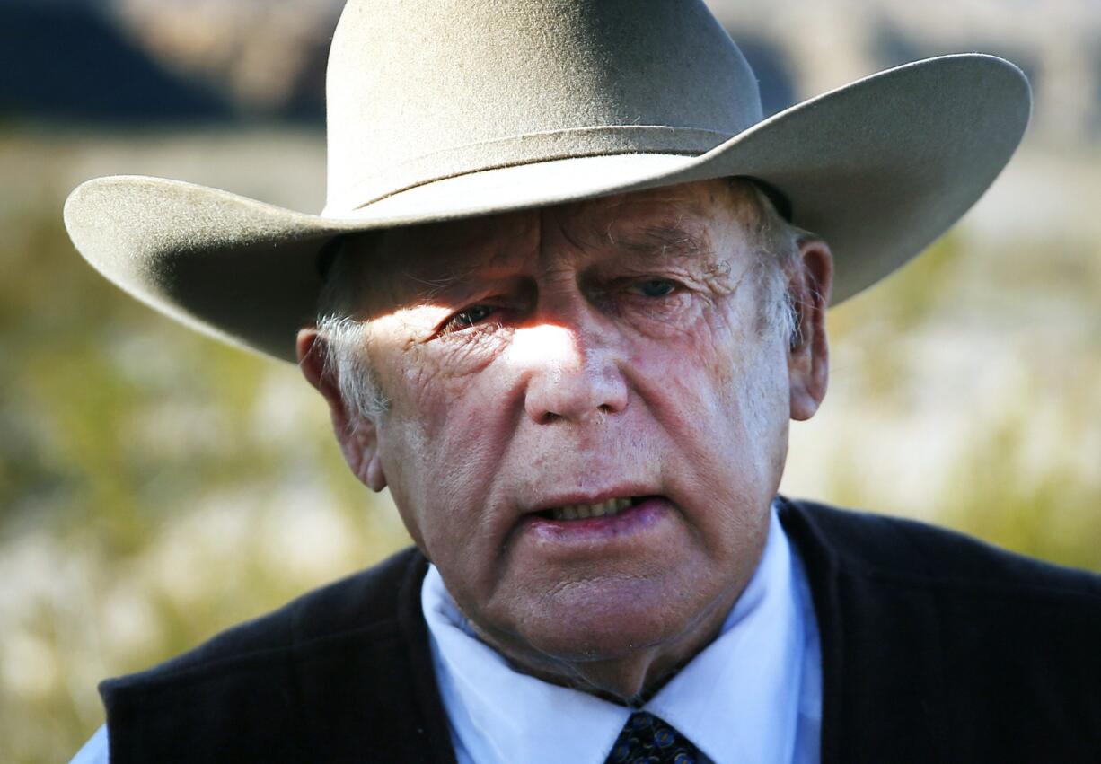 Rancher Cliven Bundy speaks Jan. 27 to media while standing along the road near his ranch, in Bunkerville, Nev. Bundy is expected to tell a judge on Thursday, whether he has hired a lawyer; enter a plea to charges in a 16-count indictment filed March 2 against him and 18 other people; and seek release pending trial on a date yet to be set.