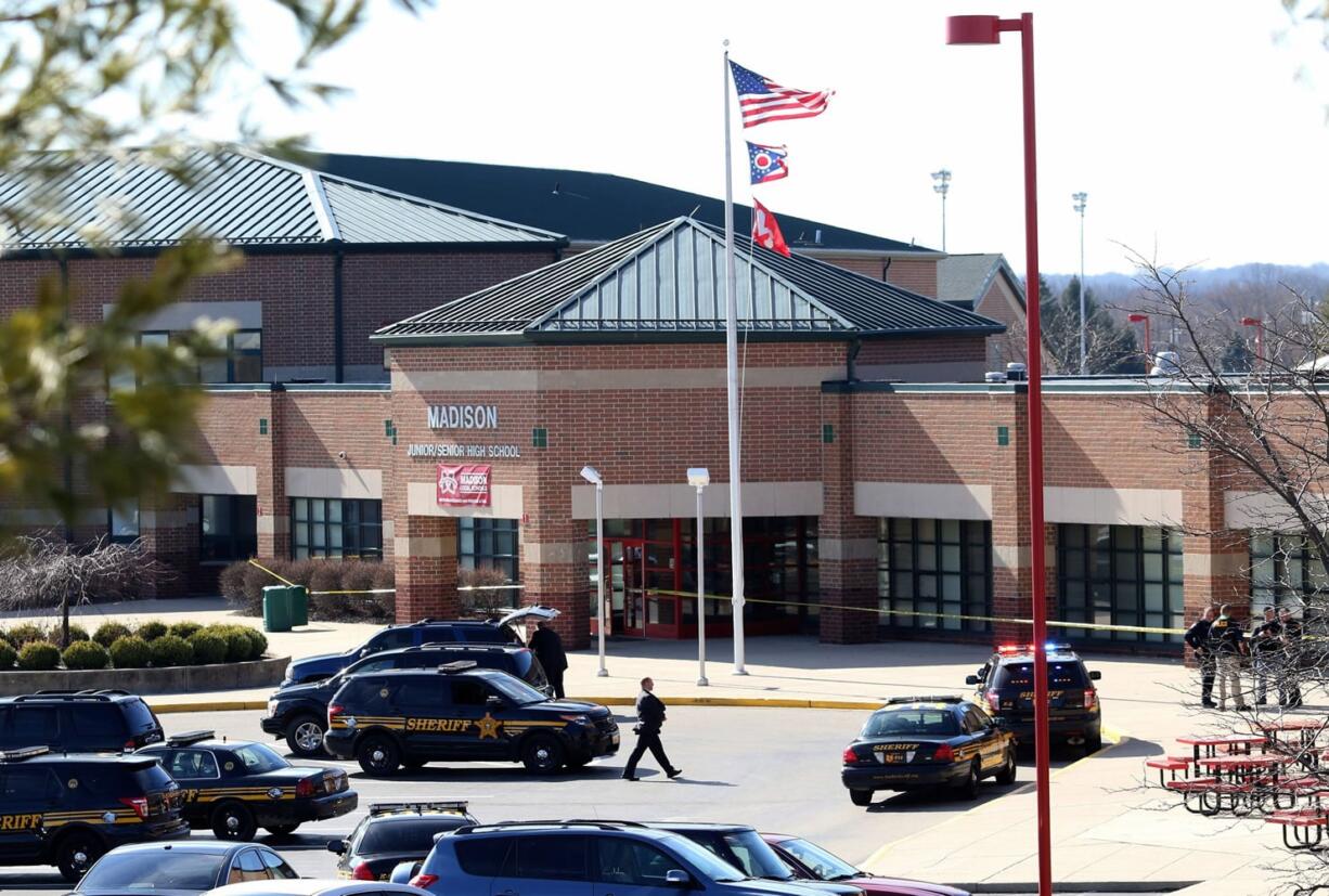 Butler County Sheriff Deputies stand on the scene at Madison Local Schools, Monday, Feb. 29, 2016, in Madison Township in Butler County, Ohio, after a school shooting. An Ohio sheriff says a 14-year-old suspect in the school shooting that wounded multiple classmates is in custody.