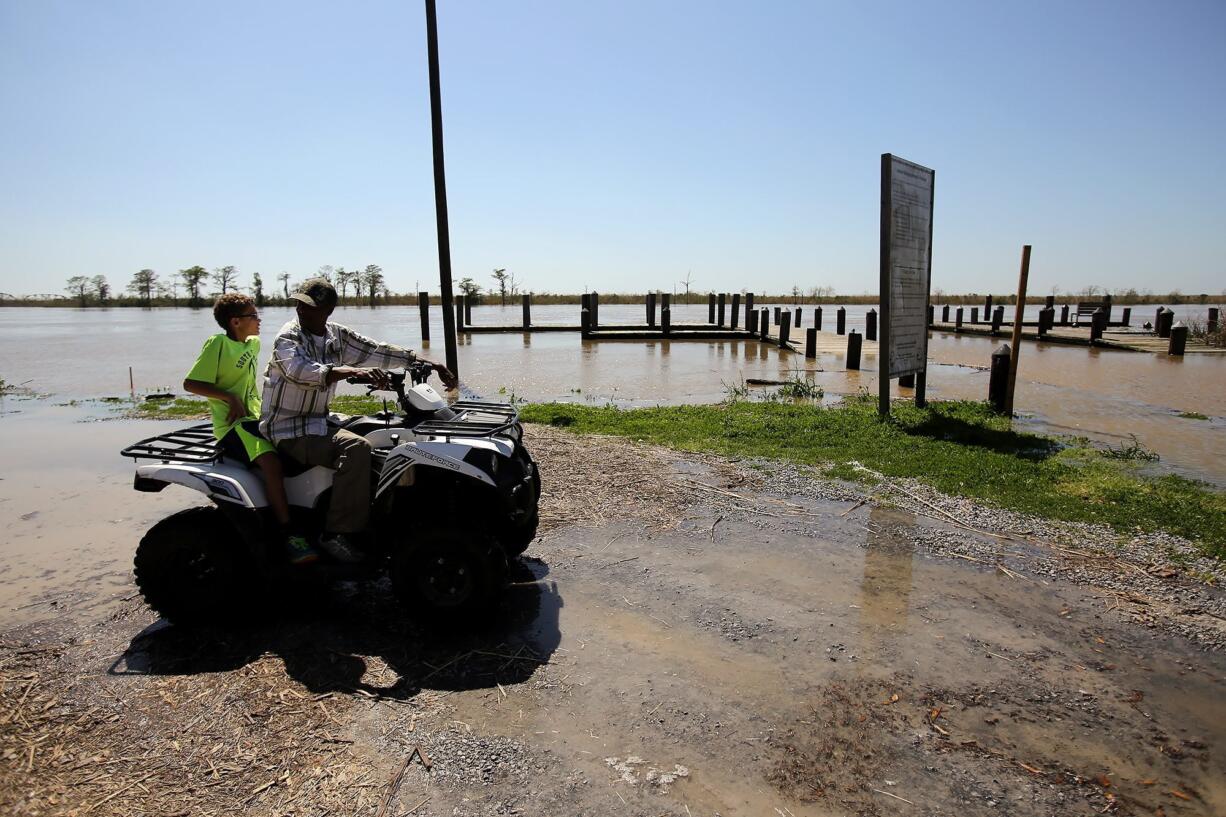 Frank Acker and his nephew, Cornelius, 9, inspect the Pearl River to see how much it&#039;s flooded on Monday in Pearlington, Miss. The river is expected to crest at 21 feet today.