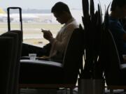 Air travelers wait in the Admiral&#039;s Club at the Dallas-Fort Worth International Airport in Grapevine, Texas. As families and individuals start to book summer travel, a debate is rising about whether airlines make it too hard to choose the most affordable options.