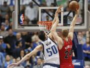 Dallas Mavericks forward Salah Mejri (50) fouls Portland Trail Blazers forward Mason Plumlee (24) during overtime of an NBA basketball game Sunday, March 20, 2016, in Dallas. Dallas won in overtime 132-120.