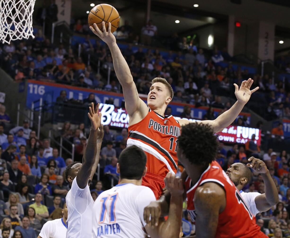 Portland Trail Blazers forward Meyers Leonard, top, shoots over Oklahoma City Thunder guard Anthony Morrow, left, and center Enes Kanter, bottom center, in the second quarter of an NBA basketball game in Oklahoma City, Monday, March 14, 2016.