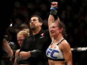 Tacoma's Miesha Tate, right, celebrates victory over Holly Holm during their UFC 196 women's bantamweight mixed martial arts match, Saturday, March 5, 2016, in Las Vegas.