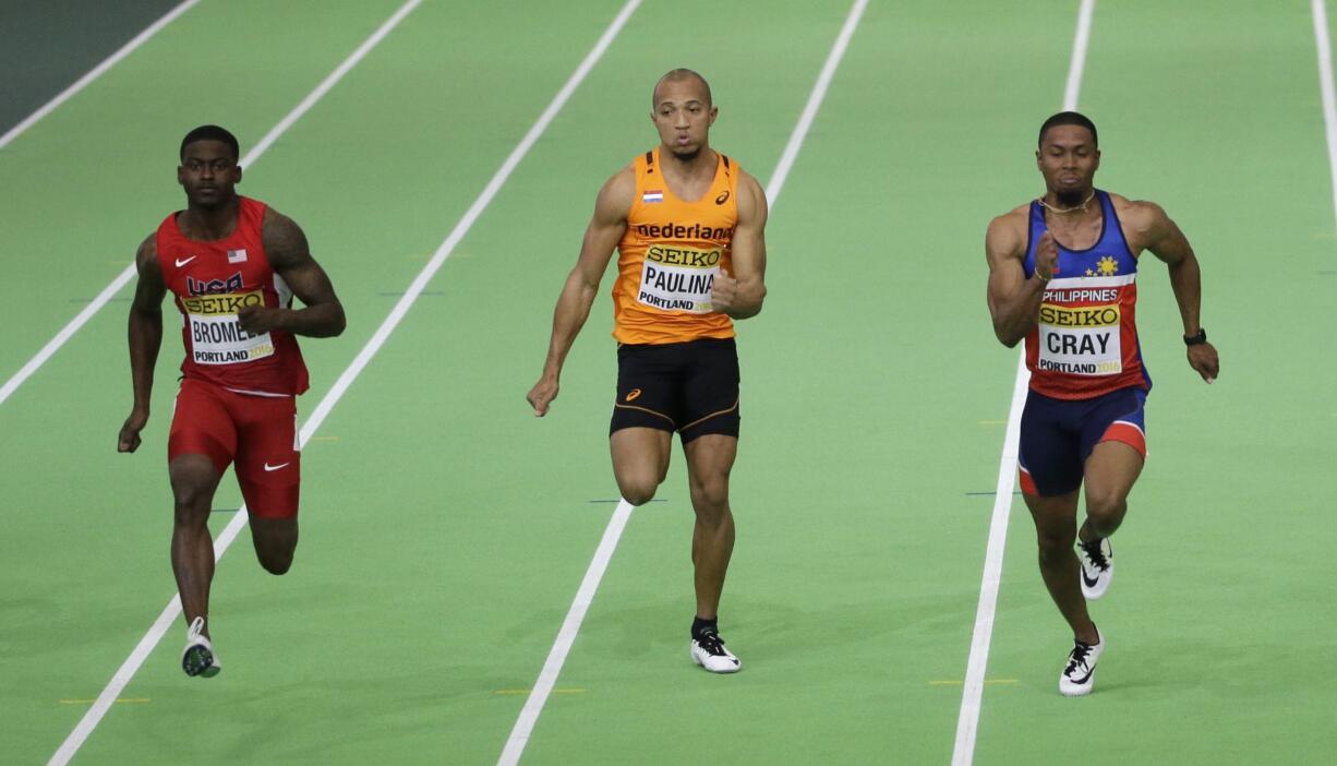 From left, United States' Trayvon Bromell, Netherlands' Hensley Paulina, and Philippines' Eric Cray compete compete in a heat  of the men's 60-meter sprint during the World Indoor Athletics Championships, Friday, March 18, 2016, in Portland, Ore.