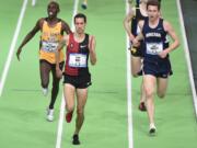 Ryan Hill beats Paul Chelimo, left, to the finish line to win the men&#039;s 3,000 meters as Troy Faley, right, gets lapped at the U.S. indoor track and field championships in Portland, Ore., Friday, March 11, 2016.