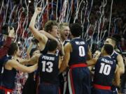 Tournament MVP Gonzaga forward Kyle Wiltjer, top left, celebrates with teammates after defeating Saint Mary's in an NCAA college basketball game for the West Coast Conference men's tournament championship Tuesday, March 8, 2016, in Las Vegas. Gonzaga won 85-75.