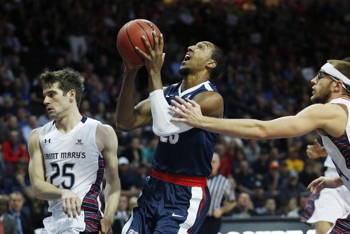 Saint Mary&#039;s forward Calvin Hermanson, right, fouls Gonzaga guard Eric McClellan, center, during the first half of an NCAA college basketball game for the West Coast Conference men&#039;s tournament championship Tuesday, March 8, 2016, in Las Vegas. Saint Mary&#039;s guard Joe Rahon is on the left.