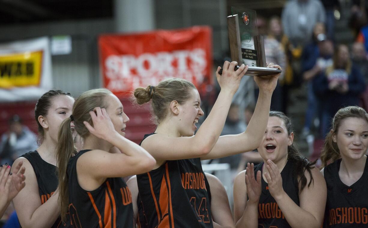 Washougal High School’s Raeann Allens hoists the fourth-place trophy as she and her teammates celebrate after beating Black Hills High School 50-28 in the class 2A girls state basketball tournament March 5, 2016 in the Yakima SunDome in Yakima, Wash.