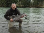 Frank Adams of Orting, Wash., holds a winter steelhead he caught in the Cowlitz River near the trout hatchery.