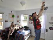 Red Cross volunteer Jeff Kuter installs a smoke alarm in Haven Reinhart&#039;s room during last year&#039;s Home Fire Campaign.