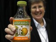 Susan Fink, founder and brewer of Karma Kombucha, holds a bottle of her Ginger Orange kombucha beverage at the Good Food Festival&#039;s financing and innovation conference on March 24 at the UIC Forum in Chicago.