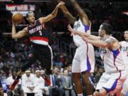 Portland Trail Blazers&#039; C.J. McCollum, left, looks to pass as Los Angeles Clippers&#039; DeAndre Jordan, center, and Clippers&#039; J.J. Redick, right, defends during the second half of an NBA basketball game, Monday, Nov. 30, 2015, in Los Angeles. The Clippers on 102-87.