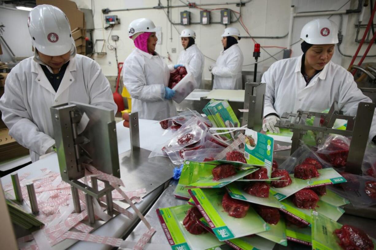 Rosalva Gusman, left, and Siria Hernandez package cuts of beef on April 4 at the Chicago Meat Authority for PRE Brands, which offers 100 percent grass-fed beef. PRE Brands has a contract with the Chicago Meat Authority.