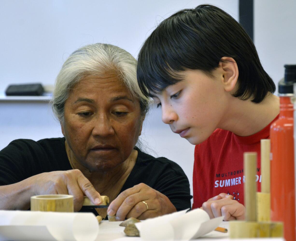 Bernice Akamine, left, helps 12-year-old Davin Carsten of Vancouver carve a pattern into a piece of bamboo Sunday afternoon during a stamp-making workshop at Clark College. Akamine&#039;s art is included in a show titled &quot;Woven: The Art of Contemporary Native Basketry&quot; at the college&#039;s Archer Gallery.