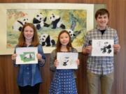 North Salmon Creek: Annika Carlson, from left, Jennifer Chun, and Stefan Zucktriegel pose with their logo designs for the Washington State Panda Foundation.