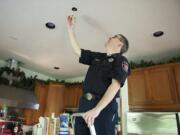 Camas-Washougal Fire Department Deputy Fire Marshal Randy Miller exposes a home sprinkler unit in the kitchen of his house.