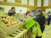 Volunteer Linda Luke, left, assists Martha Aguayo of Vancouver as she shops for produce at a Food Bank Fresh stand set up at St. John Lutheran Church in Hazel Dell.