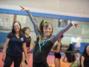 Gymnast Gigi Gernhart finishes her bar routine with a flourish Monday afternoon, April 11, 2016 at Naydenov Gymnastics.