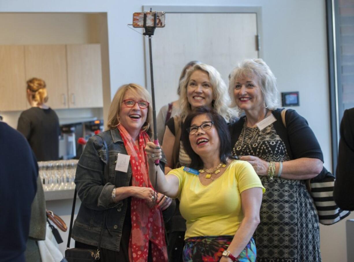 Rhona Sen Hoss, campaign manager for Sen. Annette Cleveland, center, takes a selfie with Stacey Graham, president of the Humane Society for Southwest Washington, from left; Kate Sacamano, YWCA director of philanthropy; and Teresa Lawwill of the Greater Vancouver Chamber of Commerce during a meeting of the giving circle Empower Women + Girls.